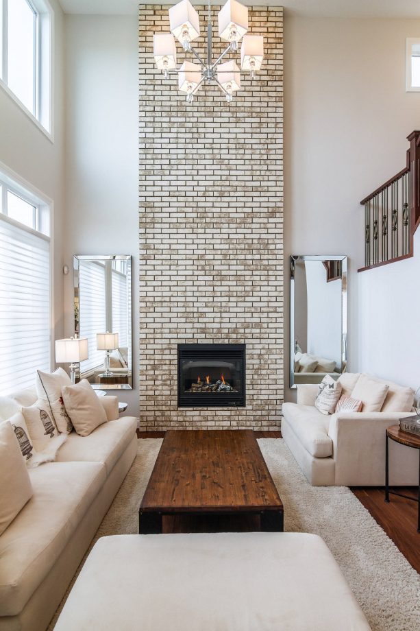 transitional living room with chiffon white wall paint and greige wall-size brick fireplace