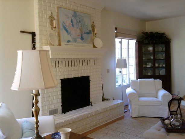 eclectic living room with white brick fireplace with mantel shelf and white wall