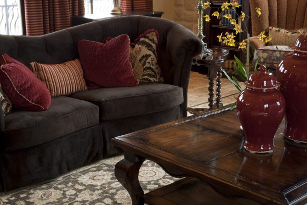 elegant contemporary living room with brown wood sofa with wine red pillows