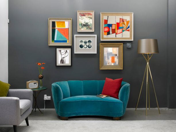grey and blue contemporary living room with red cushion and warm-toned wall arts