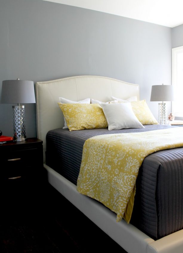 grey and white bedroom with butter yellow blanket and pillows