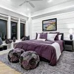 purple and grey beach-style bedroom with fluffy rug and ottomans