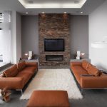 grey and brown living room with a brick wall