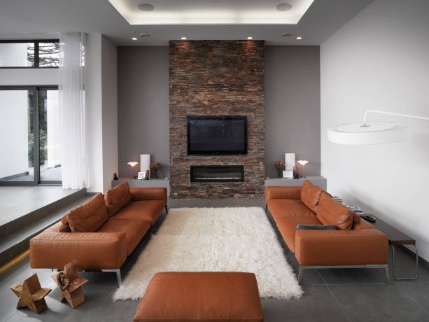 grey and brown living room with a brick wall