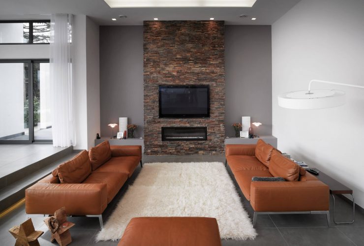 grey and brown living room with a brick wall