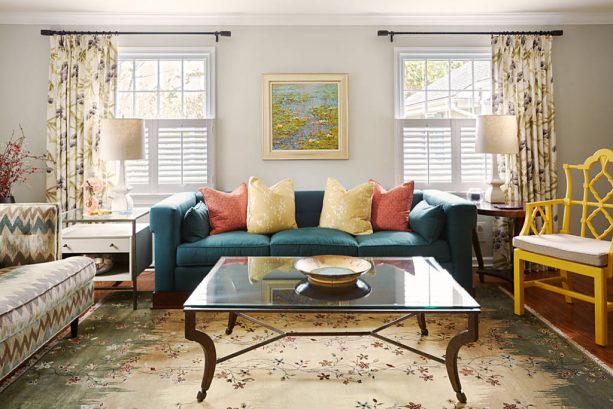 grey and teal living room with rust and yellow pillows