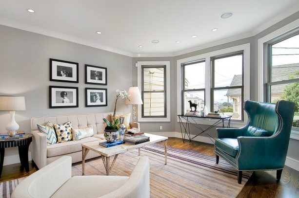 nailhead trimmed chair in a grey and teal living room