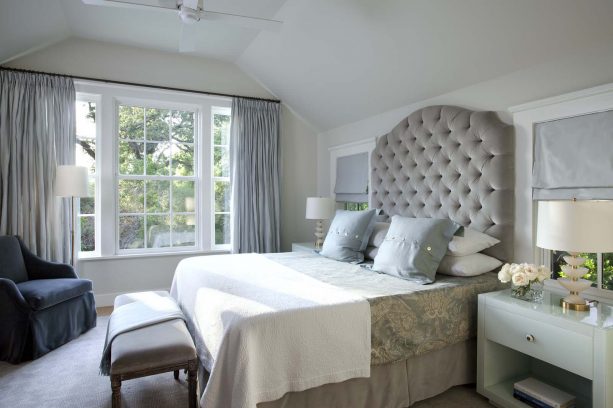 blue and grey bedroom with oversize tufted upholstered headboard