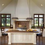 cream kitchen cabinets paired with red brick backsplash