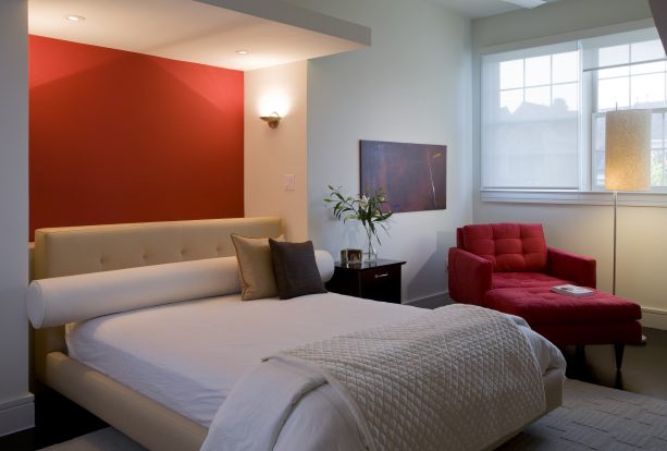 grey bedroom with small red accent wall