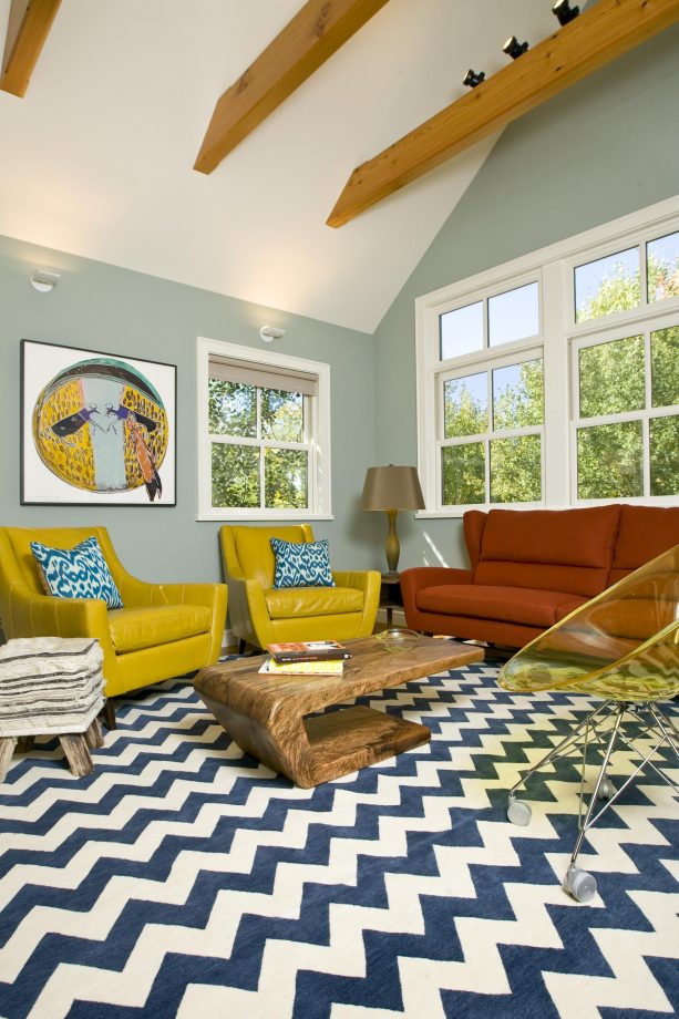 an eclectic living room with grey walls and mustard yellow artwork