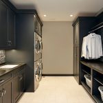 laundry room with black cabinets and beige walls