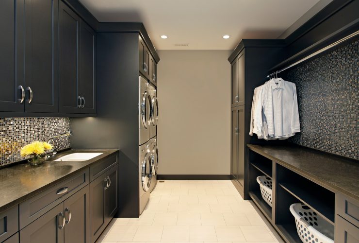laundry room with black cabinets and beige walls