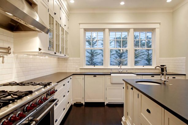 off-white cabinets with black countertops and hardware