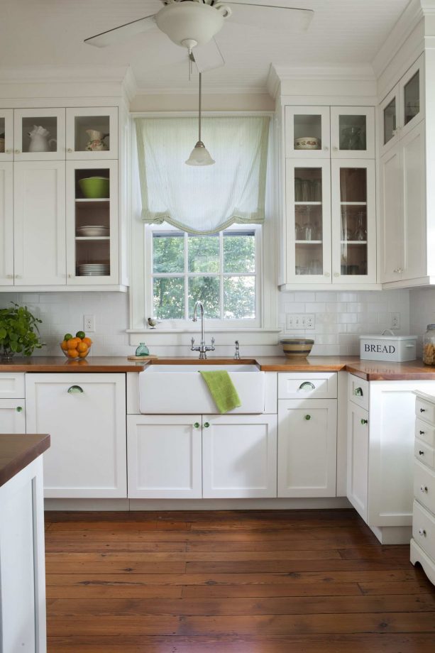white shaker kitchen cabinets with solid white sink and wooden countertops