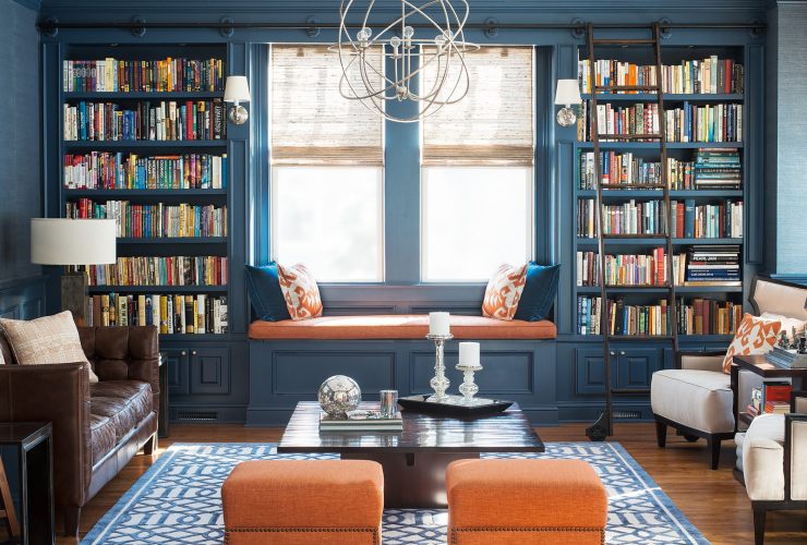 navy blue living room with orange ottomans and window seat
