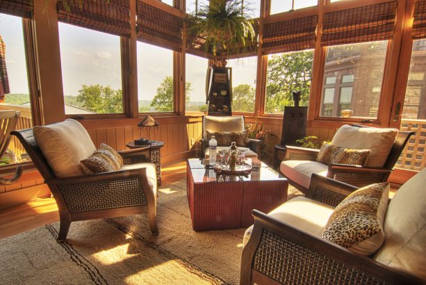 an eclectic porch with roll-up bamboo blinds