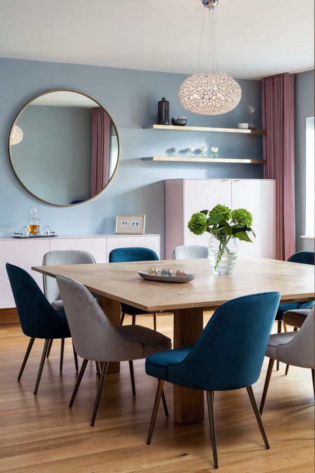 a contemporary dining room with soft blue walls and soft pink full-length curtains)