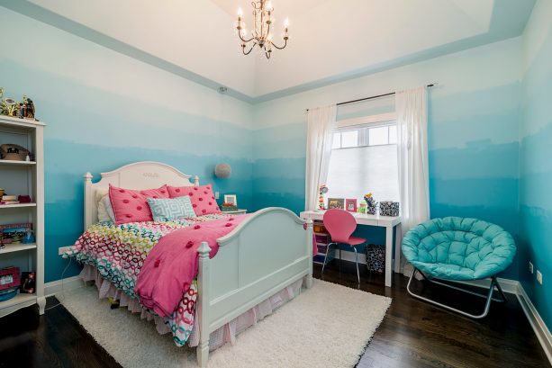 a transitional kids bedroom with ombre blue walls and white curtains