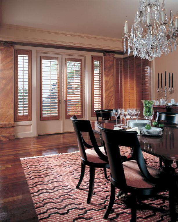French door glasses covered by brown-stained plantation shutters