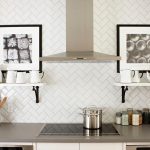 Herringbone style beveled white subway tile with gray grout detail