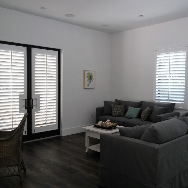 black French doors covered by white plantation shutters