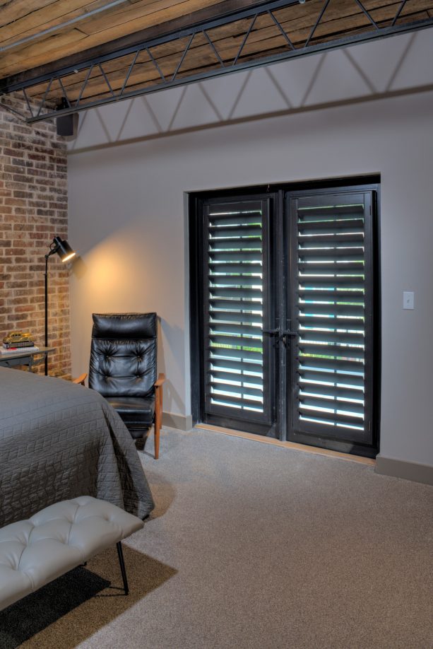 black French doors with stained black plantation shutters as the cover