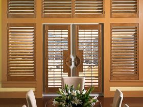 plantation shutters from medium hardwood material on white French doors