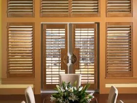 plantation shutters from medium hardwood material on white French doors