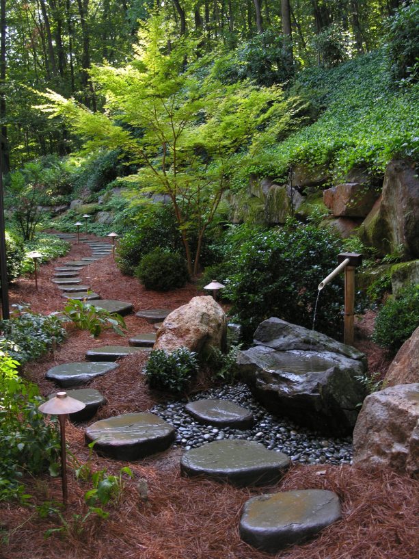 an amazing traditional landscape with real bluestone stepping stones and pine needles mulch