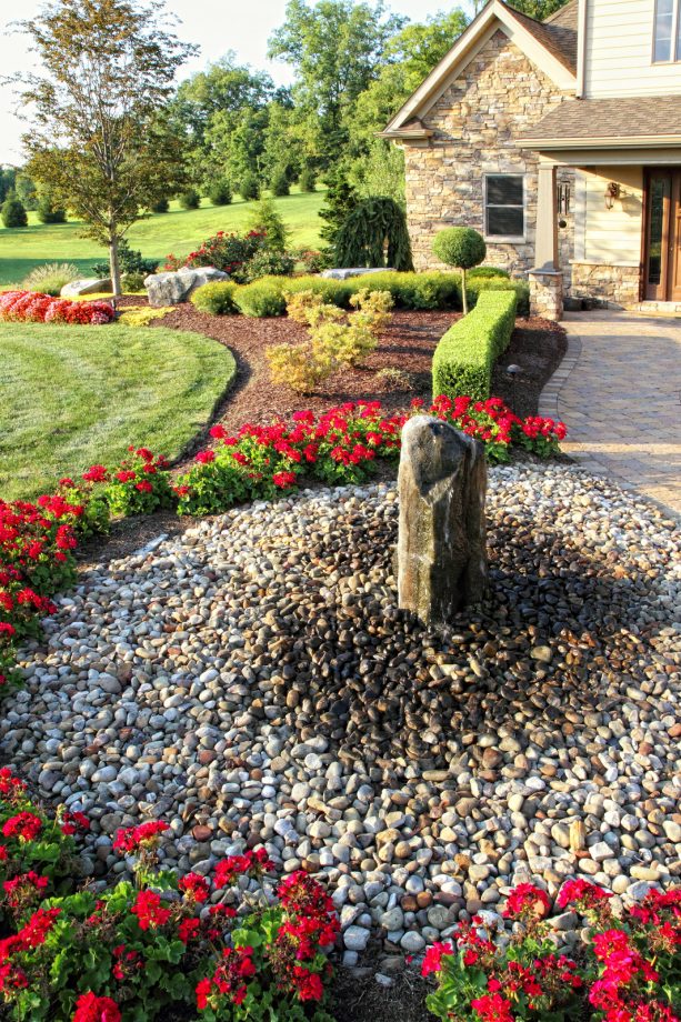 stone water fountain with rock mulch on the ground