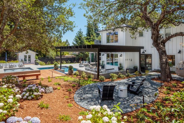 transitional backyard landscape with brown mulch and rock patio