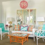 a contemporary living room with turquoise chairs and gold mirror