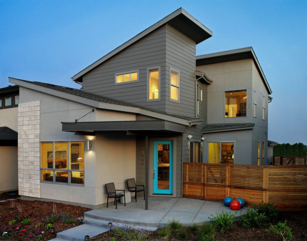 a dark grey contemporary exterior with turquoise entry