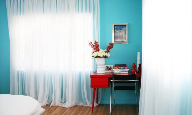 a red desk and turquoise wall in a contemporary bedroom