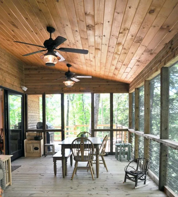 a rustic porch with tongue and groove ceiling from stained knotty material