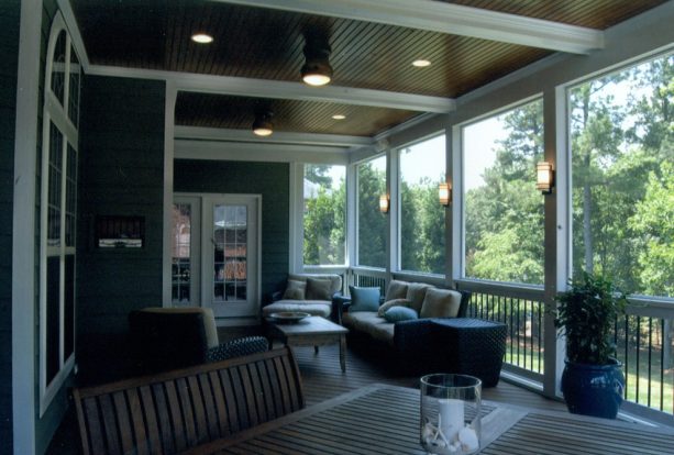 a screened beach-style porch with tongue and groove ceiling and exposed beams