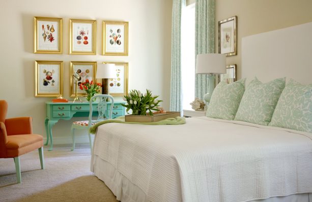 a turquoise desk and gold picture frames in a traditional bedroom