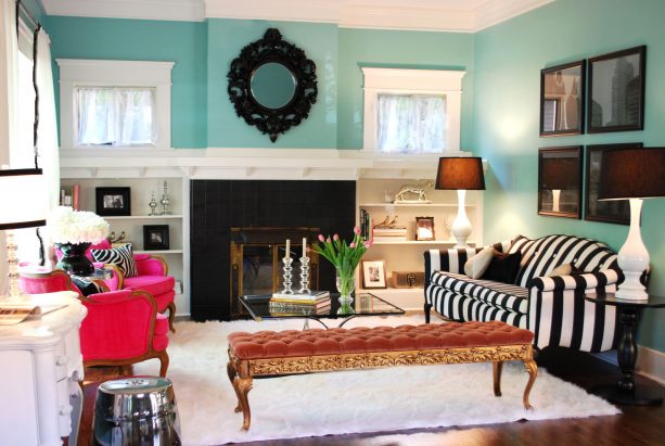 an eclectic living room with turquoise walls and black accents