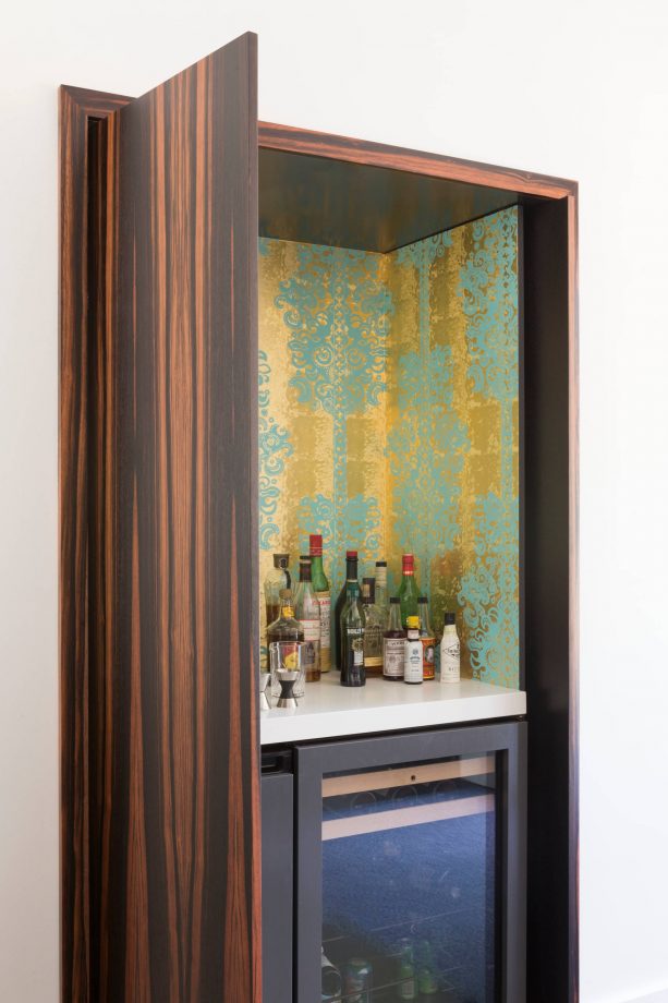 turquoise and gold wallpaper in a home bar design