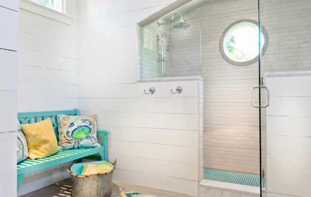 turquoise bench in a warm-white beach-style bathroom