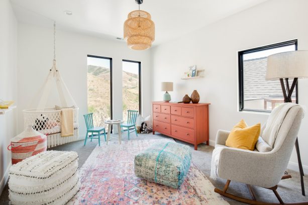turquoise chairs and coral drawers in a transitional nursery room