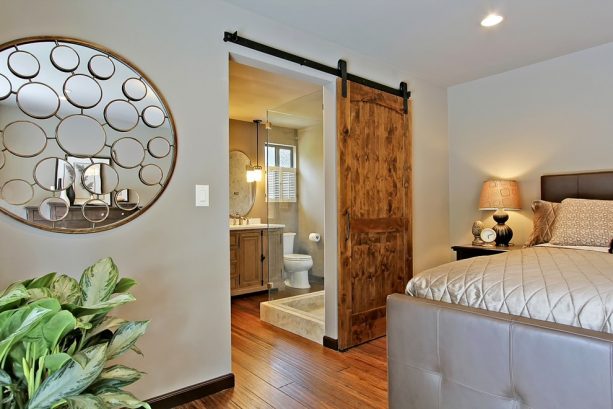 a bathroom barn door with industrial-style hardware and track