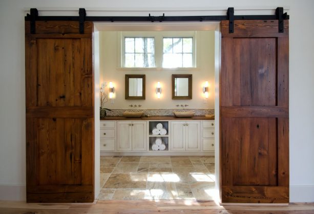 a master bathroom behind double sliding barn door