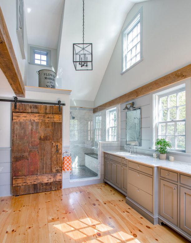 a wide sliding barn door in a farmhouse bathroom