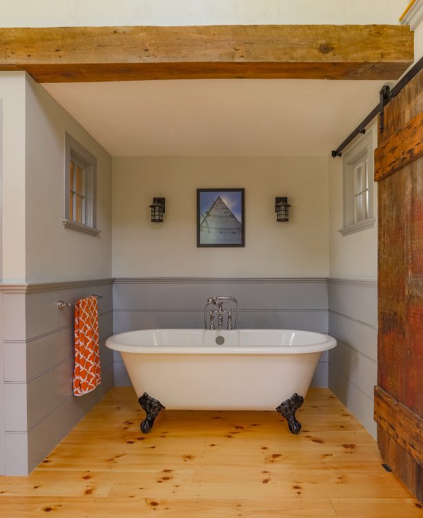the barn door slides in front of the wall on the tub side
