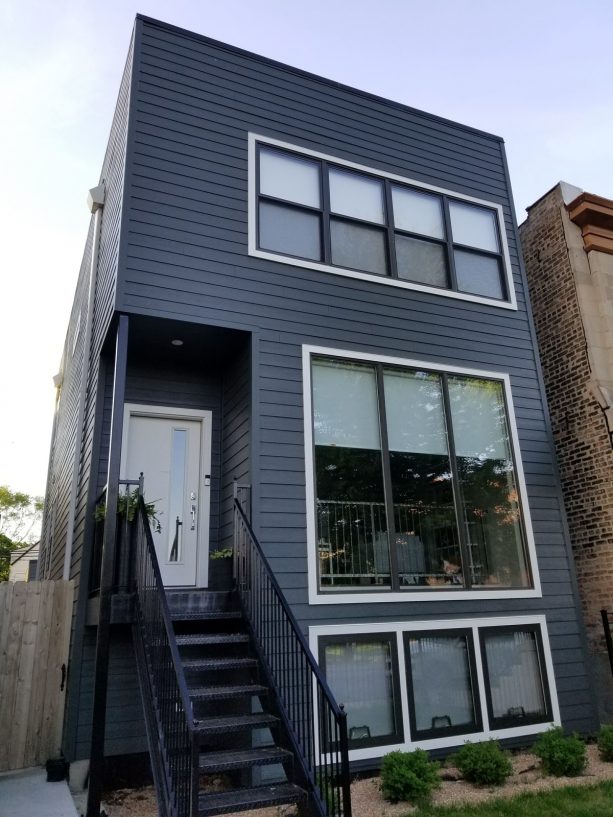 a modern home exterior design with dark grey walls and white trim