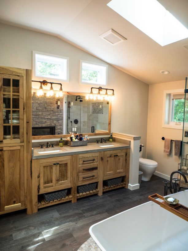 a rustic bathroom with custom hickory cabinets and unique dark wood floor