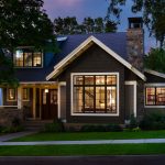a welcoming exterior with dark grey paint, white trim, and dark wood door