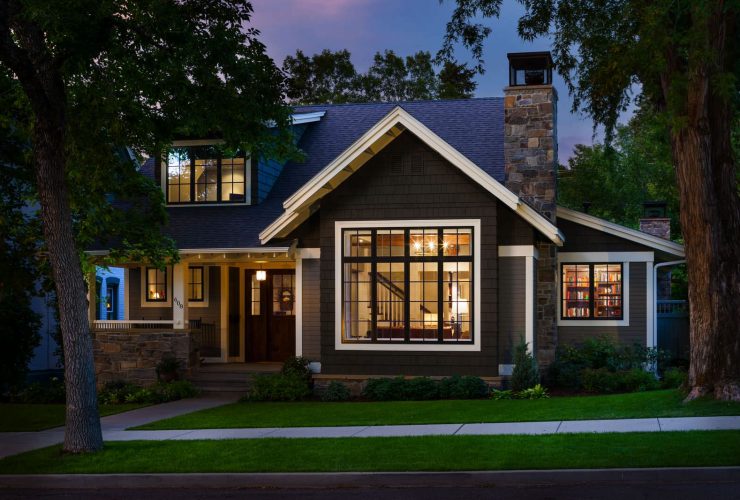 a welcoming exterior with dark grey paint, white trim, and dark wood door